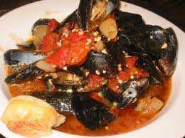 quando l'aglio è rosolato, toglierlo, aggiungere i pomodori - scottati e pelati, il sale, il pepe e il prezzemolo. Ridurre la salsa, aggiungere le cozze e coprire la pentola.