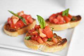Toast bread in the oven (200 ) and brush with garlic. Spread tomatoes, cheese, olives, basil and origan, salt and oil.