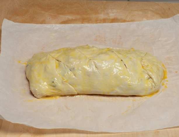 Place your hands under the towel and pull dough from centre to large and long sides trying to make dough larger and thinner, don t brake dough.