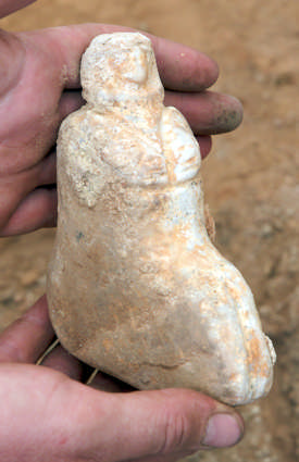 yönündedir. Dolayısıyla 2 katlı Figurine 18545.X1 from Building 79 house fill. It is a seated figure on base with small animal head protruding between the legs, carved from limestone.