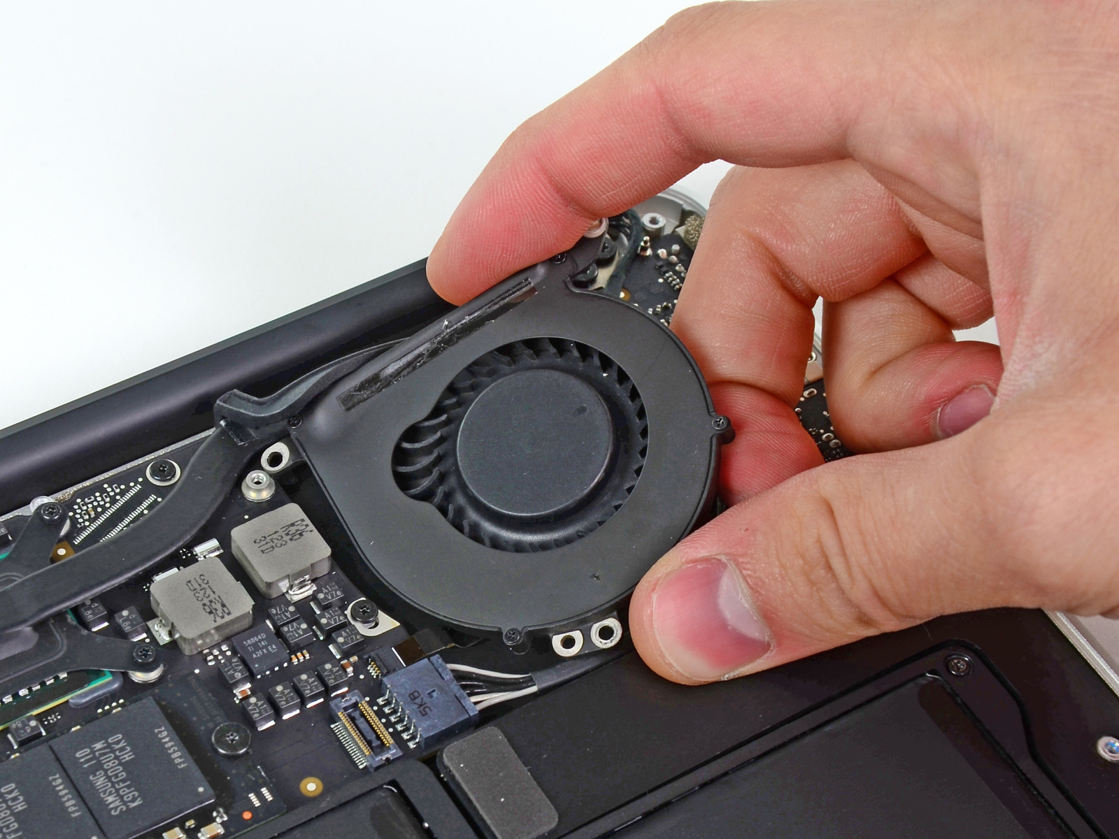 MacBook Air 13 "Mid 2011 Büyük Harf Değiştirme Adım 9 harfe fanını tutan aşağıdaki üç vidayı çıkarın: Bir 3.6 mm T5 Torx vida Bir 2.7 mm T5 Torx vida Bir 3.