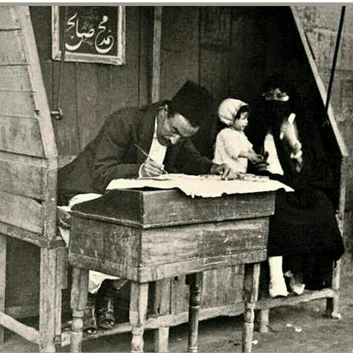 Küçük barakasında bir arzuhalci. Arkadaki tabloda Muhammed Sabih yazmaktadır. 1855, 1893 ve 1894 tarihli belgelerde İstanbul daki hakkak ve arzuhalcilerin durumuyla ilgili bilgiler bulunmaktadır.