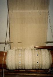 Şekil 12: Dikey tezgahta gergi dokuma Weaving apron on vertical loom Şekil 13: Gergi boyandıktan sonra Apron, after dyed kök boyalı olmasına rağmen üzerindeki renkli püsküller