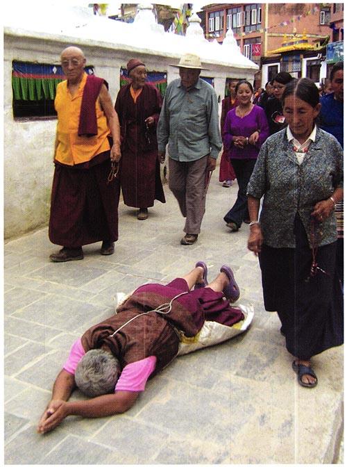 Boudhanath Stupası'nın etrafı nı secde ederek dönen yaşlı rahibe.