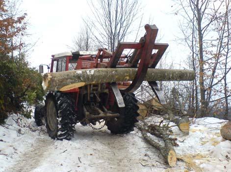 . Şekil 2. Yol üzerinde sabit duran traktör ile tomrukların çekilmesi (Foto: E.İlhan) 3.2. Yükleyici olarak tarım traktörlerinin kullanılması Bölmeden çıkarılan orman ürünleri burada yol kenarına makine veya insan gücüyle istif edilerek sekonder transport için hazırlanmaktadır.