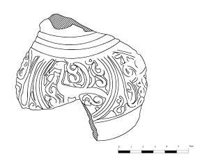 Gövdeden boyuna geçişte üç sıra kabartmalı yiv dizisi görülür. Parçanın yüzeyinde yuvarlak bir madalyonun içinde, uzun kuyruklu ve uzun boyunlu bir kuş figürü bulunmaktadır.