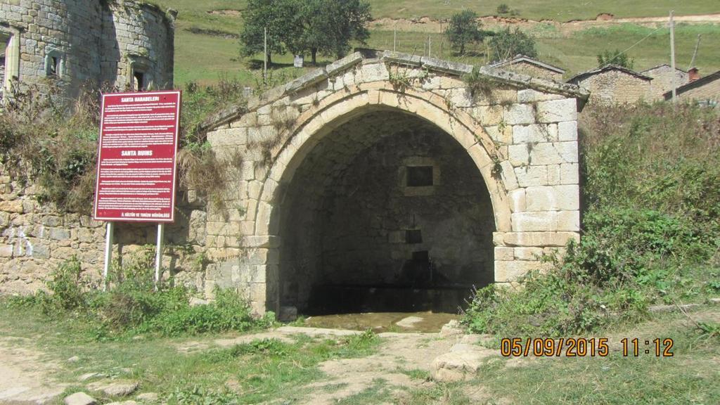 Foto 10. Santa da taş malzeme kullanılarak yapılmış tarihi bir çeşme ve hemen yanında farklı konumlara konulmuş olan tanıtım levhası. Günümüzde Santa, mevsimlik bir yerleşme özelliği taşımaktadır.