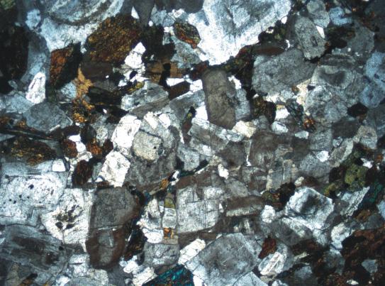 karışımından oluşan çift kırınıma sahiptirler. Bazı kristaller kapanımlar içerebilmektedir. Rölyefi yüksek olan kristallerin kirli sarı pleokroizma sunmaktadırlar. hbl hbl hbl Bio Q hbl hbl 0.