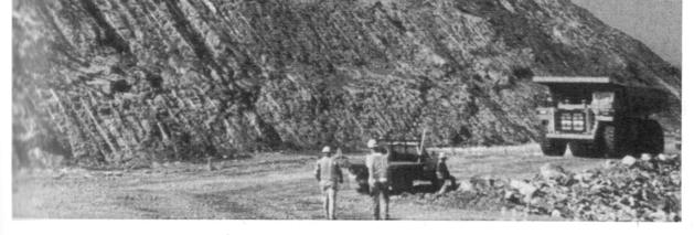 10 Bir karayolu projesinde kaya yarması için kontrollü patlatmaya örnek (sağlam, çok kıvrımlı gnays; I- 26/US23, Mars Hill yakını, Kuzey Carolina) (fotoğraf izni: Department of Transportation).