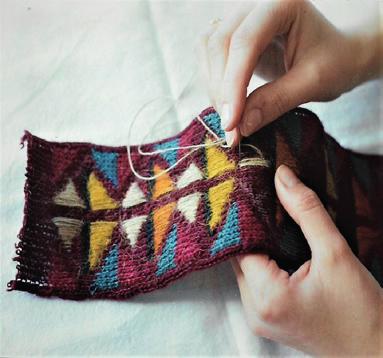 İki renk sistemine göre örülen çanta üzerine çorap motifleri elde işleme