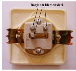 Örneğin bir sınıftaki lambaları iki ayrı grup hâlinde yakıp söndürmek için kullanılır. Adi anahtarların iki bağlantı vidası olmasına rağmen, komütatör anahtarların üç bağlantı vidası vardır.