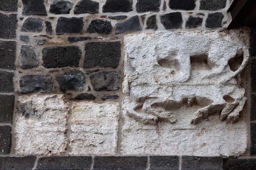Kemerin güneye bakan yüzünün, sur duvarıyla birleştiği bölümlerinde dikine yerleştirilmiş kitabe bölümleriyle bu kitabelere alt dış köşelerinden eklemlenen aslan-boğa mücadele sahneleri bulunmaktadır