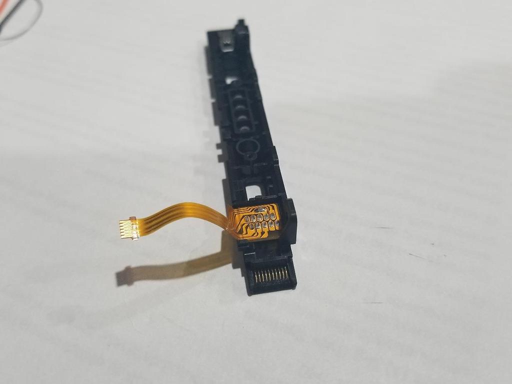 2. JoyCon'un kızak konektörünü sökmek için bir Phillips tornavida kullanın (Görsel 15) ve şerit kabloları çıkartmadan dikkatlice sökün (Sadece katlanmalı).