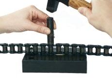 Taşıyıcı pimler blok üzerinden çekiç yardımıyla aşağı itilir ve pim zımbası (B) ile zincirden çıkartılır.