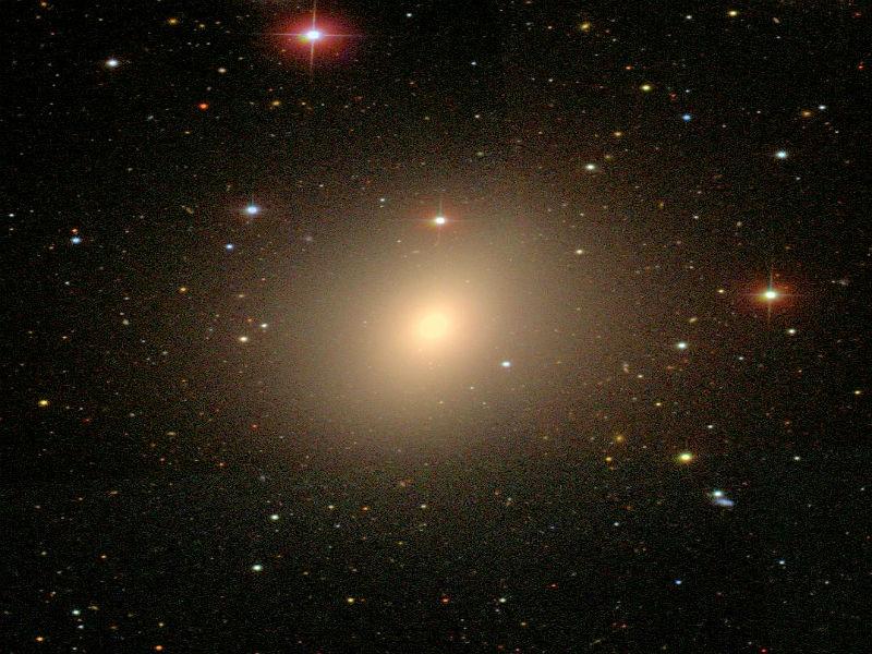 ile gösterilirler. (E0: daire biçimine en yakın, E7: ovalliğe uzanan) NGC 4621, eliptik galaksilere bir örnektir (Fotoğraf NASA/ESA Hubble). Var olan galaksilerin çoğu eliptiktir.