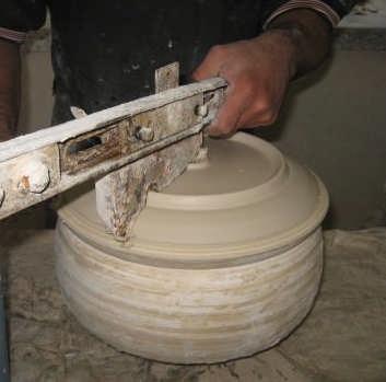 Resim 3.4: Şablon ile tabağın şekillendirilmesi Çamurun şablona sıvanmaması için şablonun ön yüzeyi su ile ıslatılır. Üretim kalıbı üzerindeki çamur fazlalıkları torna çalışırken alınır.