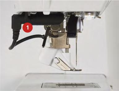 BERNINA Dikiş Düzenleyicisi (BSR) (isteğe bağlı aksesuar) > BSR ayağının kablosunu bağlantıya (1) sokun. BSR fişi düşey olarak takılabilir. > Makineyi açın.