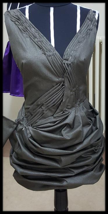 Sağ ve solda eşit olmak üzere straplez mini bir elbise tamamen drape ile kaplanmıştır.