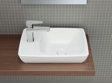 Asimetrik tezgahüstü lavabo, inceltilmiş kenarı ve zarif köşeli hatlarıyla yeni bir estetik öneri sunuyor.
