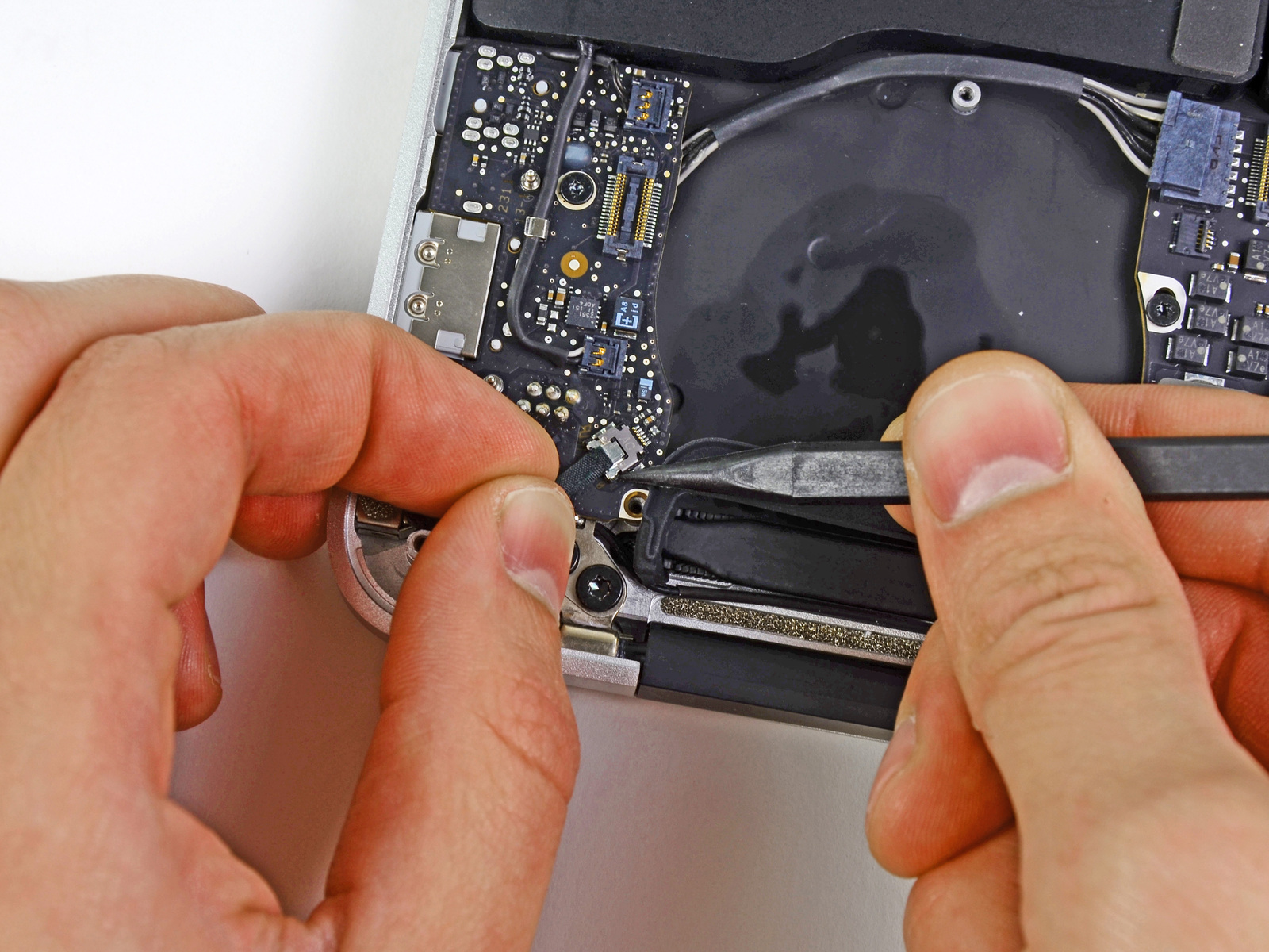 MacBook Air 13 "Mid 2011 Büyük Harf Değiştirme Adım 11 I / O Kartı mantık kartındaki prizinden uzağa güç kablosunu çekerek G / Ç kartını ayırın.