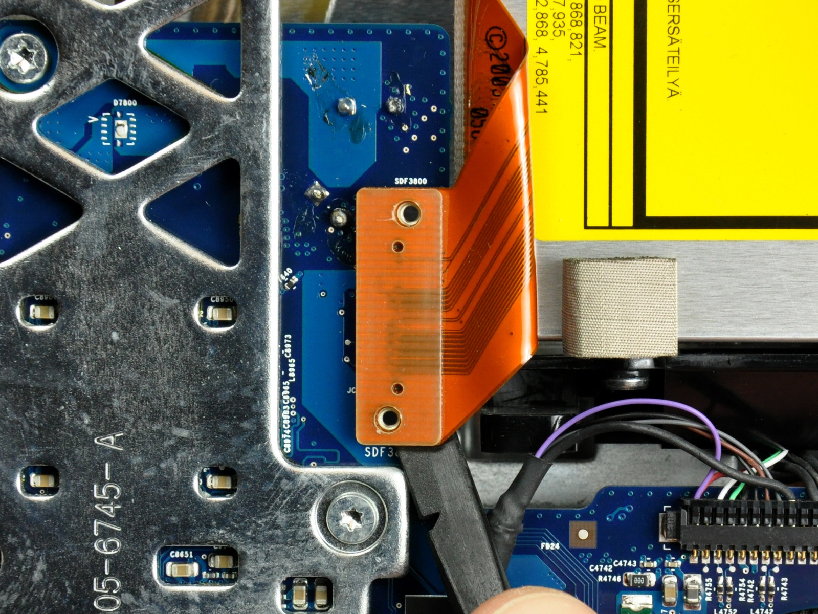 Adım 19 mantık tahtası kapalı optik sürücü şerit kablo konektörü gözetlemek için bir spudger düz ucunu kullanın. konnektörü üst veya alt gelen meraklı zaman bağlayıcı en kolay çıkarılır.
