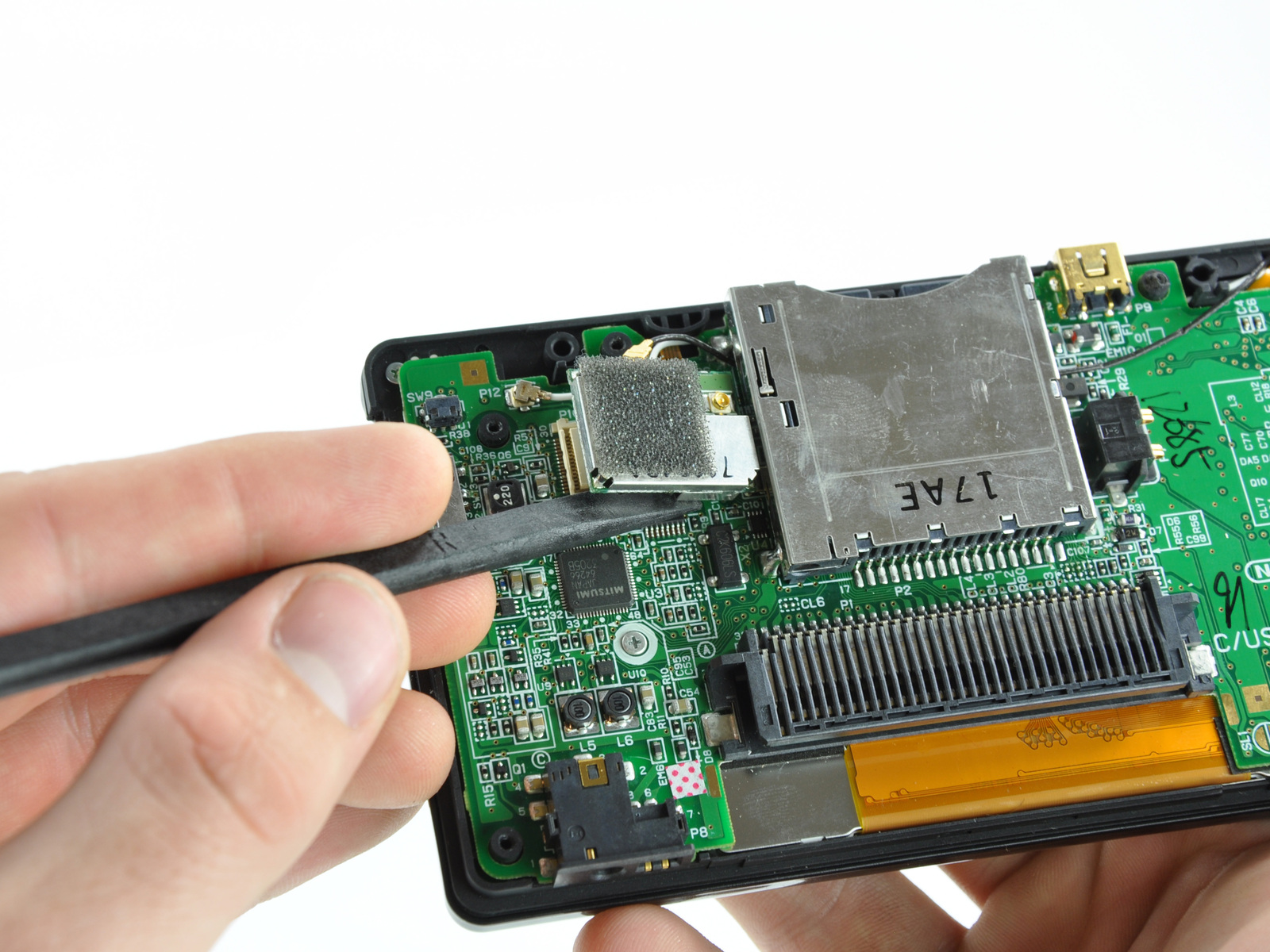 şarj olmuyor Nintendo DS Tamir Adım 9 yukarı doğru anakart üzerindeki yuvasından Wi-Fi kurulu konektörü gözetlemek için bir spudger düz kenarını kullanın.