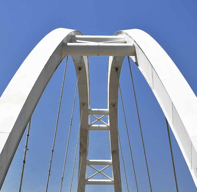 Bayraklı Asma Üst Geçit Köprüsü Köprünün 92 m uzunluğundaki ana açıklığı, 12 adet 75 m uzunlukta ithal özel çekme çubukları (tension bar) ile çelik kemere bağlanarak taşınmaktadır.
