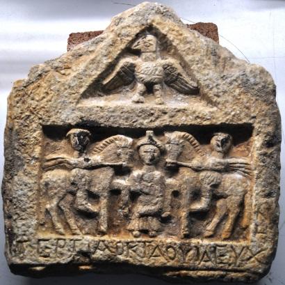 246 motifler bulunan bir kartal figürü betimlenmiştir. Stel gövdesinde merkezi bir biçimde, tanrıça olması muhtemel bir kadın figürü cepheden işlenmiştir.