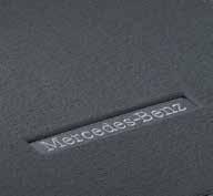 Üzerinde Mercedes-Benz yazısını taşıyan metal logoya sahip siyah kadife paspaslar.