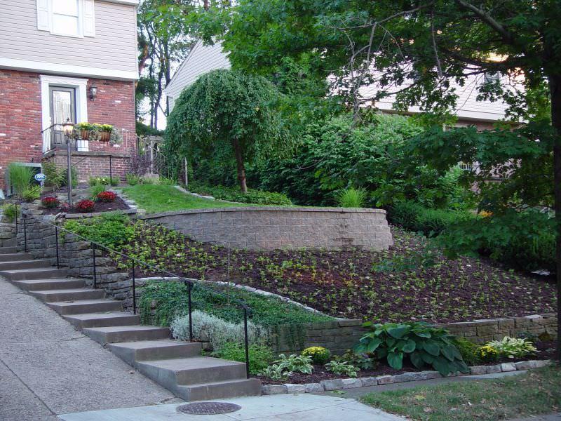 Eğimli bahçelerde taşlarla döşenmiş merdivenler ya da kat kat bahçe yapmak iyi bir
