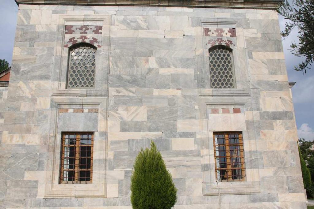 Üst pencere alınlıkları yuvarlak kemer üzerine oturan süslemeleriyle dikkat çekmektedir. Yine renkli taş ve mukarnas süslemelerin hâkim olduğu görülmektedir. Şekil 93.